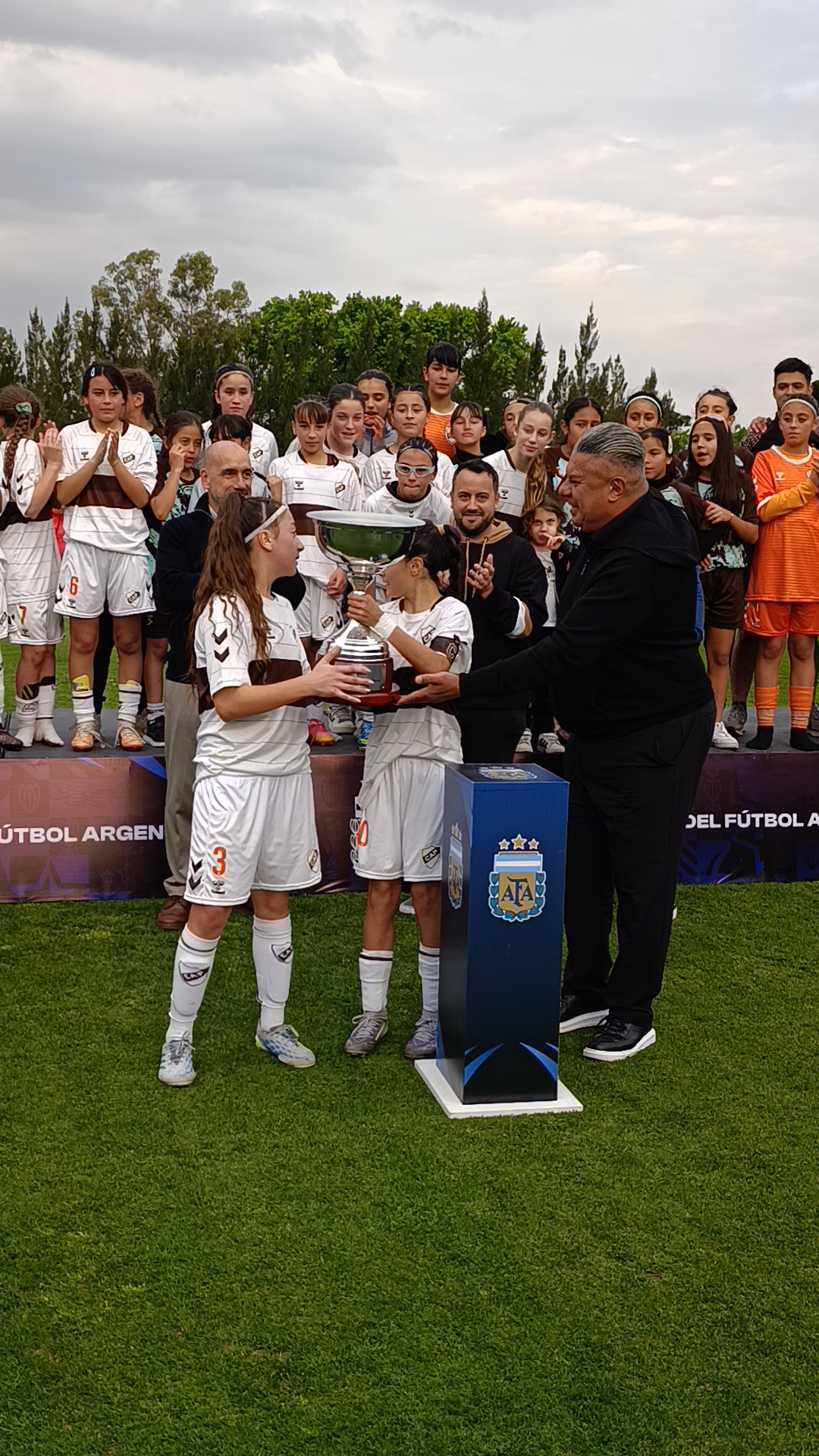 Las campeonas reciben la copa de manos de Claudio «Chiqui» Tapia.